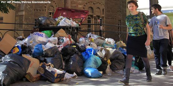 Tourists walk past uncollected garbage in Athens. Pic courtesy of washingtonexaminer.com